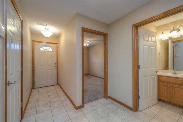 interior space with visible vents, a ceiling fan, baseboards, and light tile patterned floors
