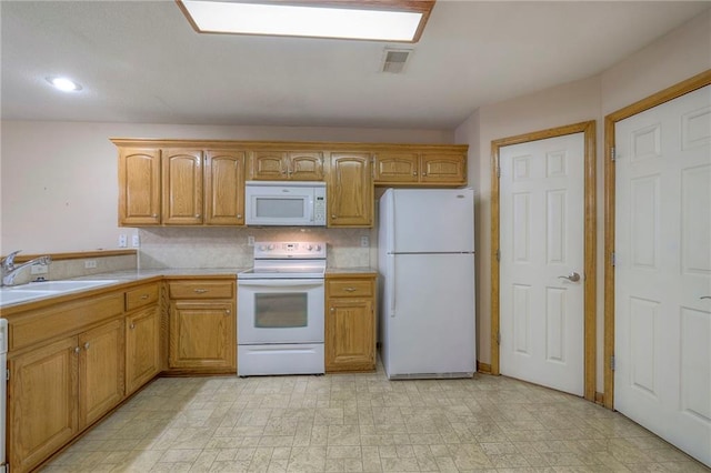 kitchen featuring a sink, light floors, white appliances, and light countertops