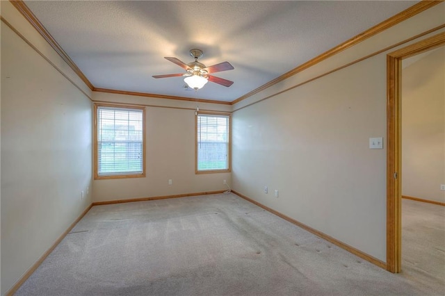 unfurnished room featuring crown molding, baseboards, a ceiling fan, and light colored carpet