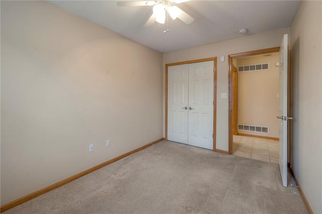 unfurnished bedroom with visible vents, carpet flooring, baseboards, and a closet