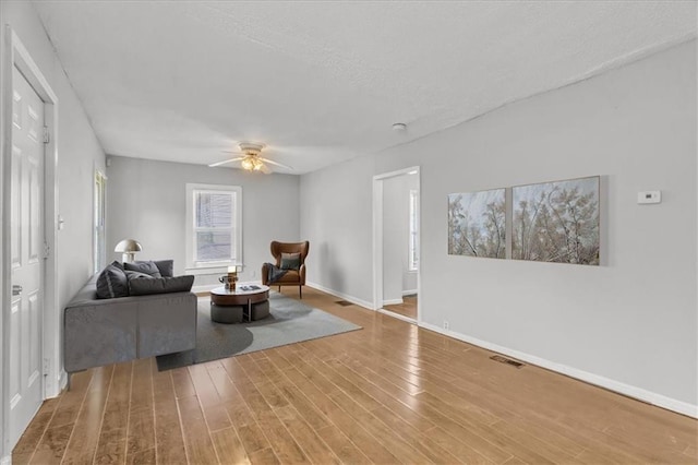 2130 E 83rd St, Kansas City, MO 64132 - living area with wood finished floors, baseboards, a ceiling fan, and visible vents