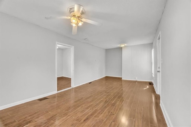 2130 E 83rd St, Kansas City, MO 64132 - empty room featuring visible vents, ceiling fan, baseboards, and wood finished floors