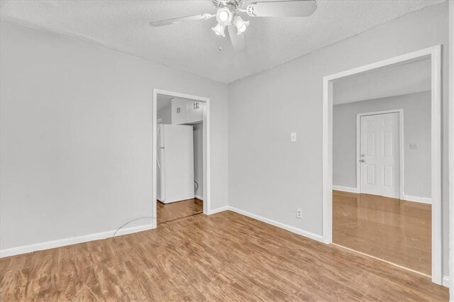 2130 E 83rd St, Kansas City, MO 64132 - unfurnished room with baseboards, a ceiling fan, wood finished floors, and a textured ceiling
