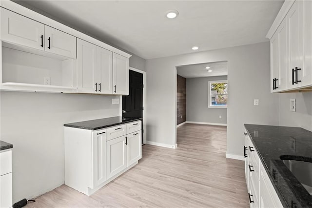 kitchen with light wood-style floors, dark stone counters, white cabinets, and recessed lighting