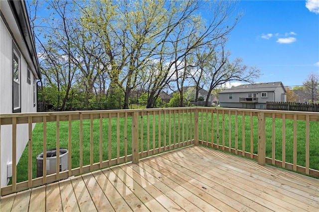 deck featuring cooling unit and a lawn