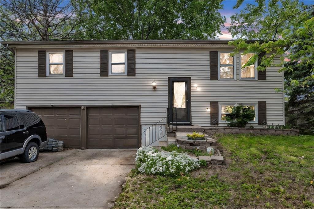 bi-level home with concrete driveway and a garage