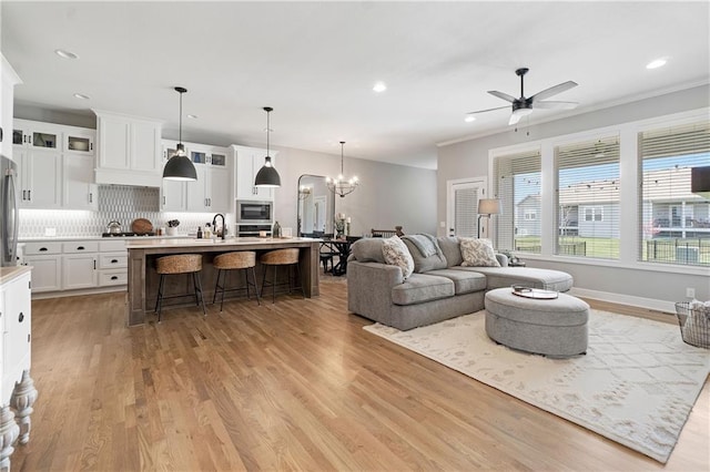16955 W 168th Ter, Olathe, KS 66062 - living area featuring light wood finished floors, ceiling fan with notable chandelier, and recessed lighting