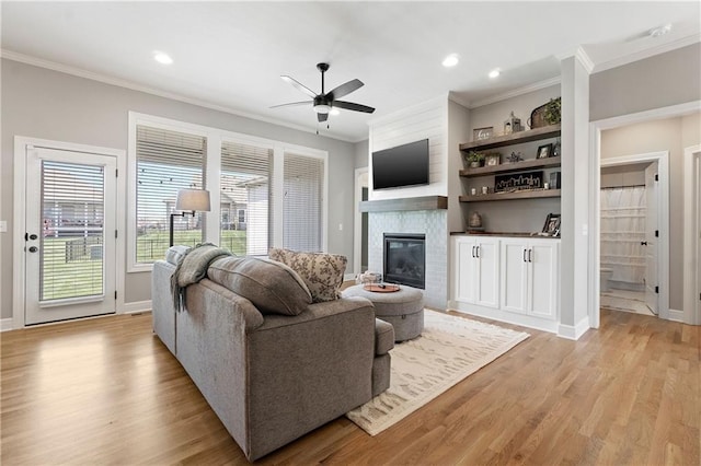 16955 W 168th Ter, Olathe, KS 66062 - living area with light wood-style flooring, ceiling fan, a large fireplace, ornamental molding, and recessed lighting
