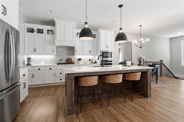 16955 W 168th Ter, Olathe, KS 66062 - kitchen featuring a sink, stainless steel appliances, a breakfast bar area, and wood finished floors