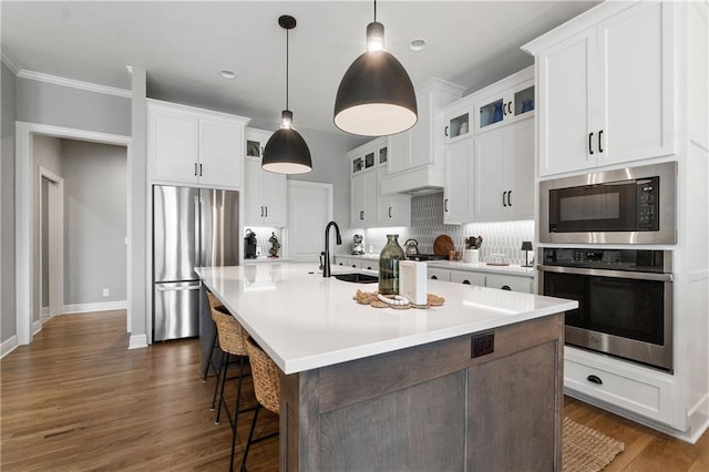 16955 W 168th Ter, Olathe, KS 66062 - kitchen featuring glass insert cabinets, an island with sink, a sink, white cabinets, and appliances with stainless steel finishes