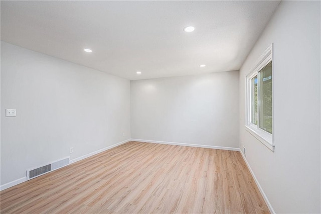 empty room featuring light wood-type flooring, recessed lighting, and baseboards