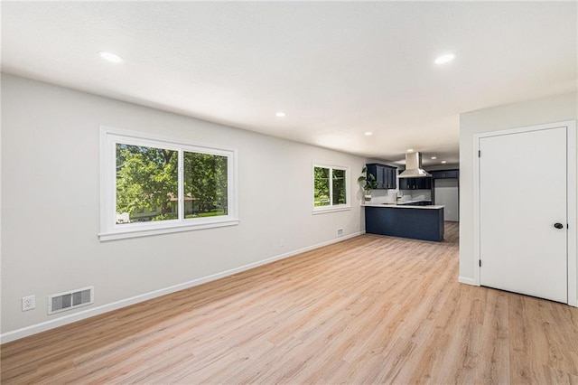 unfurnished living room featuring light wood-style floors, baseboards, and recessed lighting