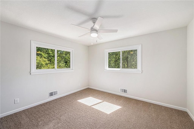unfurnished room with healthy amount of natural light, carpet flooring, and baseboards
