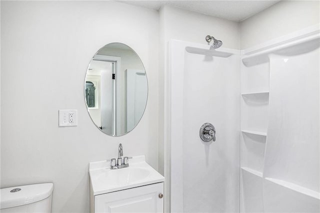 bathroom featuring a shower, toilet, and vanity