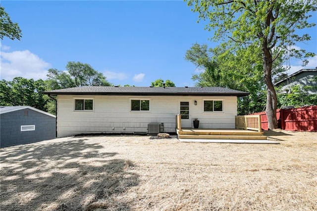 back of house with fence, a deck, and central air condition unit