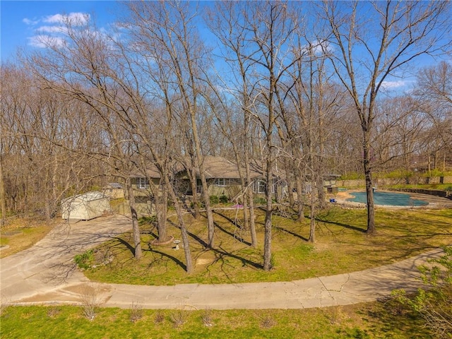 surrounding community featuring a pool and driveway