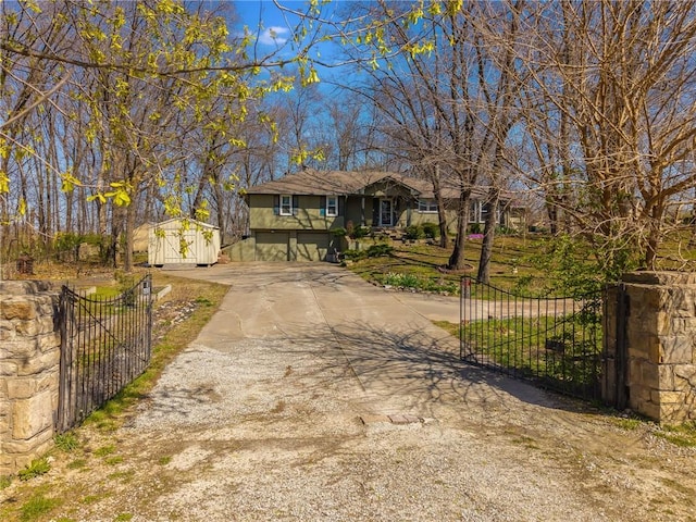 view of front of house featuring fence, driveway, an outdoor structure, and a gate