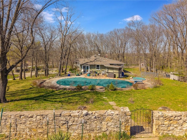 view of pool featuring a covered pool, fence, a patio area, and a lawn
