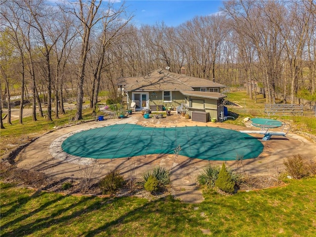 view of swimming pool with a yard, a covered pool, and a patio