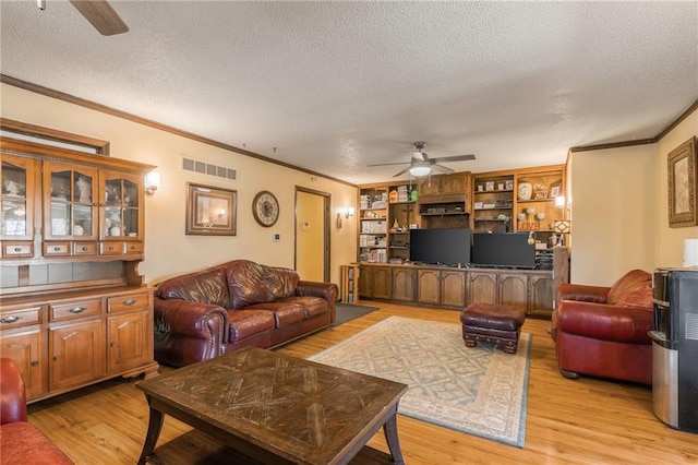 living area with light wood-type flooring, visible vents, a textured ceiling, and ceiling fan