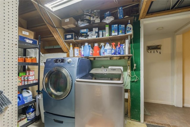 clothes washing area featuring tile patterned floors, independent washer and dryer, laundry area, and baseboards