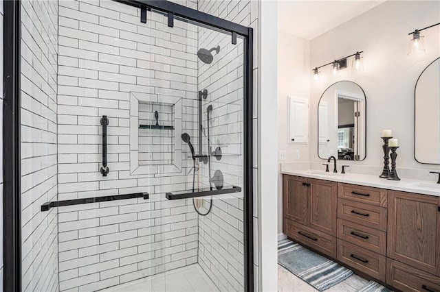 bathroom with a sink, a shower stall, and double vanity