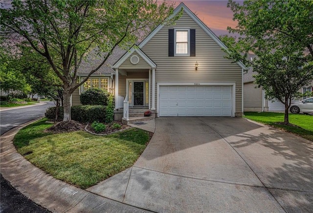 traditional home with a lawn, an attached garage, and driveway