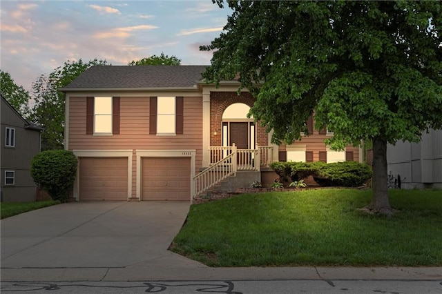 view of front of house featuring a garage, a front lawn, and driveway
