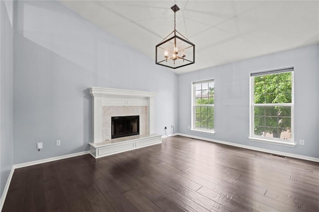 unfurnished living room with visible vents, a fireplace, a chandelier, dark wood finished floors, and vaulted ceiling