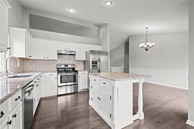 kitchen with appliances with stainless steel finishes, a sink, white cabinets, lofted ceiling, and an inviting chandelier