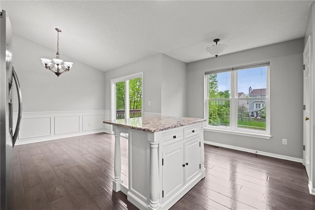 kitchen with white cabinets, a chandelier, dark wood-style floors, and a healthy amount of sunlight