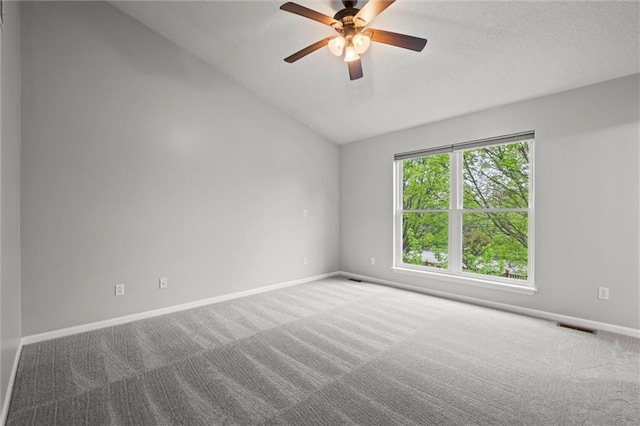 spare room with carpet floors, baseboards, vaulted ceiling, and visible vents
