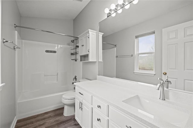 full bathroom with shower / bathtub combination, toilet, wood finished floors, and vanity