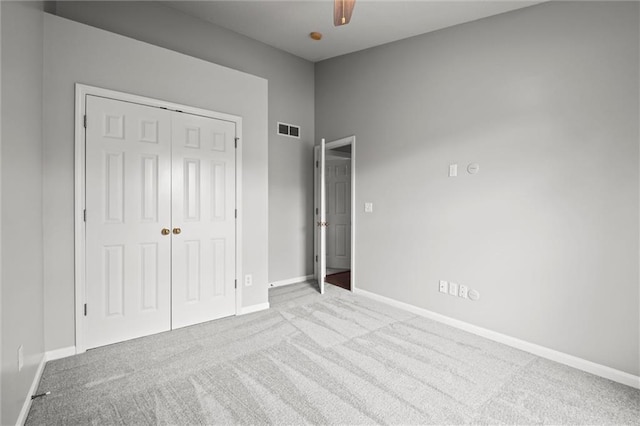 unfurnished bedroom with carpet floors, baseboards, visible vents, and a closet