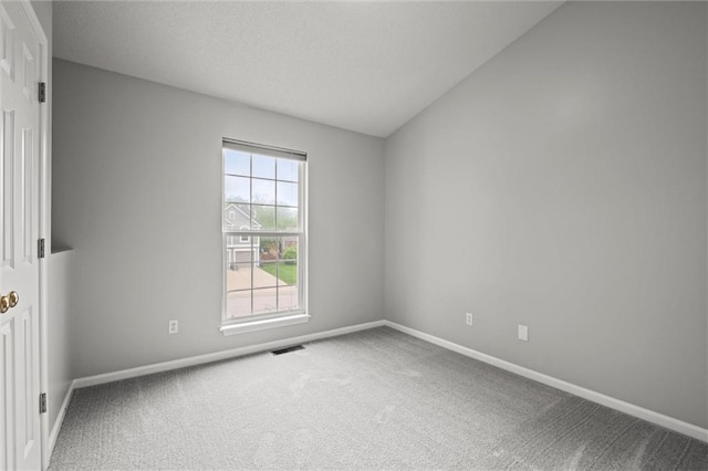 carpeted spare room featuring visible vents, a textured ceiling, and baseboards