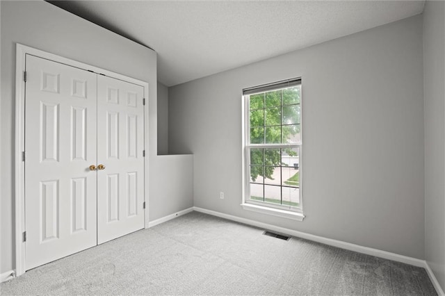 unfurnished bedroom with carpet flooring, baseboards, and visible vents