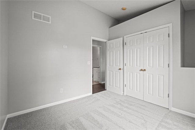 unfurnished bedroom featuring baseboards, carpet, a closet, and visible vents