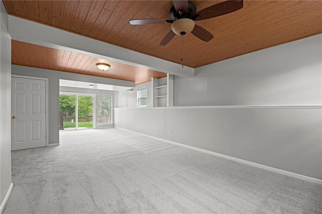unfurnished room featuring a ceiling fan, built in features, baseboards, wooden ceiling, and carpet flooring