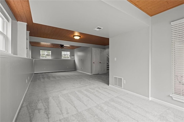 empty room featuring visible vents, carpet floors, and wooden ceiling