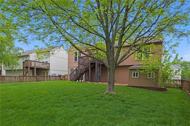 view of yard with a fenced backyard, a wooden deck, and stairway