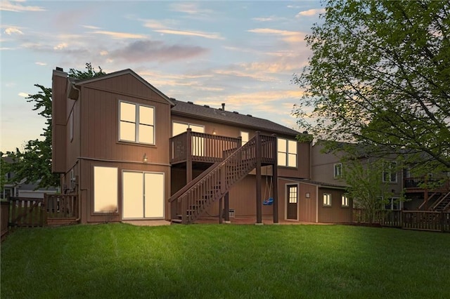 back of house with a wooden deck, fence, a chimney, a yard, and stairway