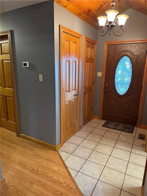 12301 S Stubbs Rd, Overbrook, KS 66524 - entrance foyer with a chandelier, lofted ceiling, light wood-type flooring, and wood ceiling