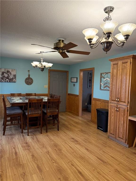 12301 S Stubbs Rd, Overbrook, KS 66524 - dining area with a chandelier, wainscoting, light wood finished floors, a ceiling fan, and wood walls
