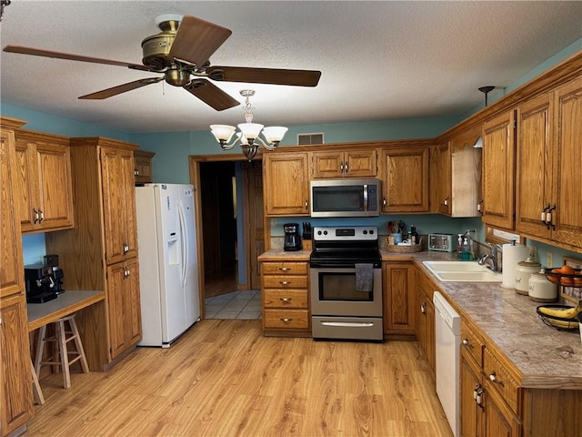 12301 S Stubbs Rd, Overbrook, KS 66524 - kitchen with appliances with stainless steel finishes, brown cabinets, and a textured ceiling