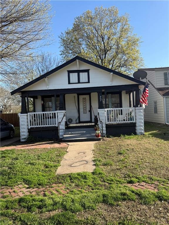 bungalow with a porch and a front lawn