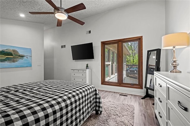 bedroom with a textured ceiling, light wood-style flooring, and visible vents