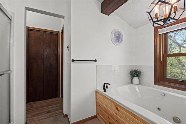 full bathroom with tile patterned flooring, a textured ceiling, a chandelier, a jetted tub, and vaulted ceiling with beams