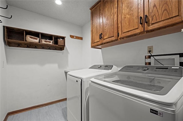 laundry room with cabinet space, a textured ceiling, recessed lighting, baseboards, and washing machine and dryer
