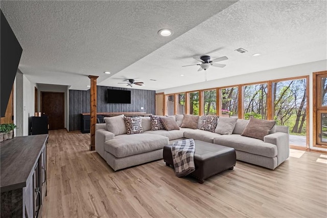 living area with recessed lighting, a textured ceiling, ceiling fan, and light wood finished floors
