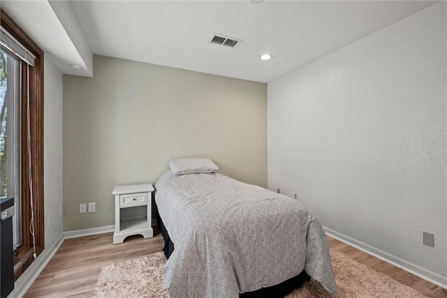 bedroom with baseboards, recessed lighting, light wood-style flooring, and visible vents